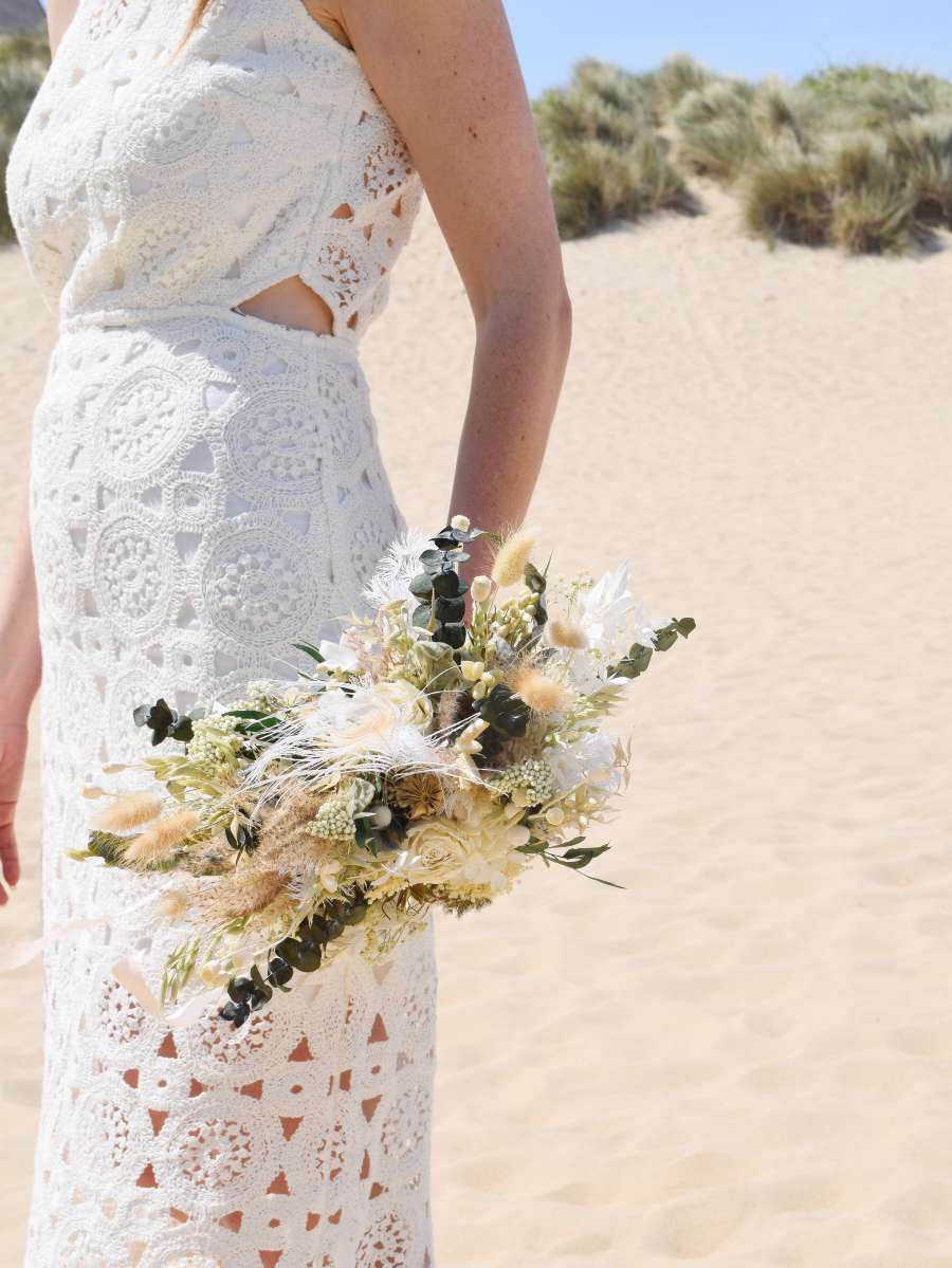 close-up van een modern X-vormig bruidsboeket met gepreserveerde rozen, pampas en eucalyptus