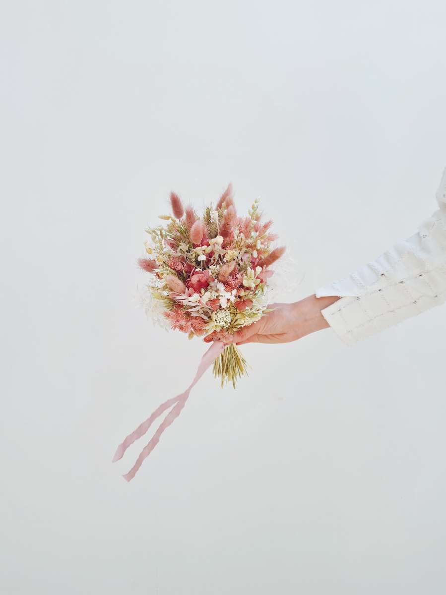 Trouwboeket met droogbloemen dat bestaat uit roze hortensia, witte glixia, asparagus, haver en roze bunny tais