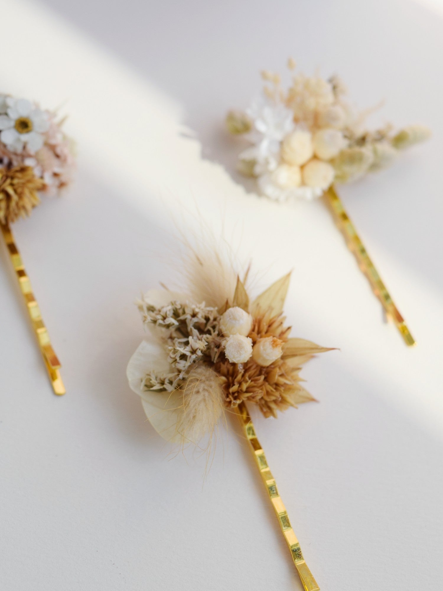 Fijne gouden haarschuivers die werden bezet met droogbloemen in natuurlijk tinten, onderdeel van de collectie handgemaakte bruidsaccessoire