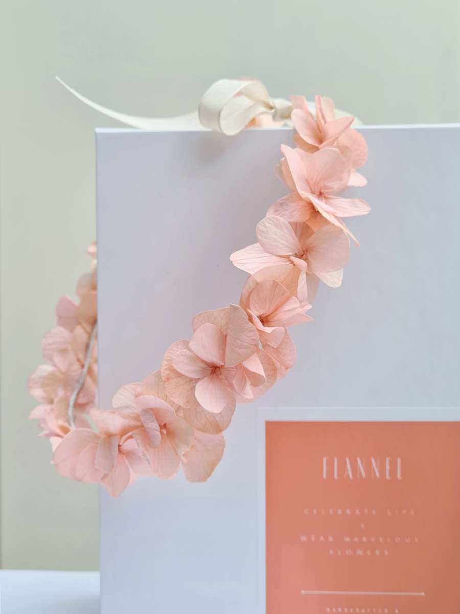 vooraanzicht van een weelderige bloemenkroon om in het haar te dragen die volledig bestaat uit pastel roze hortensiablaadjes