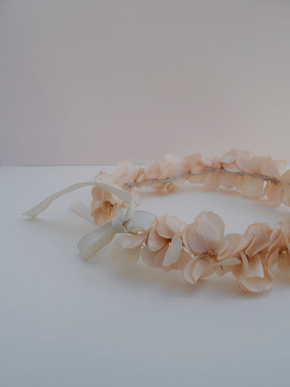 zijkant van een bloemenkroon om in het haar te dragen gemaakt van roze hortensia met een wit lint